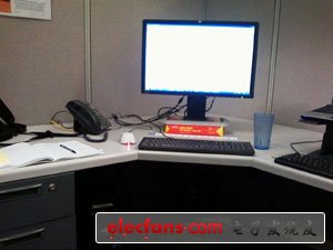 　　斯巴達(dá)式的簡(jiǎn)潔：兩臺(tái)電腦、水、電話和筆記本。