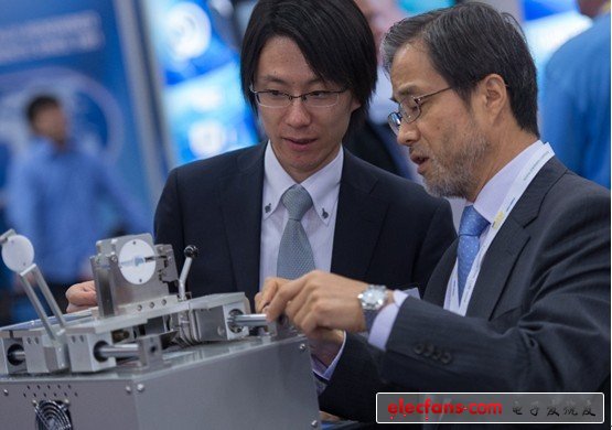 兩個(gè)與會(huì)者彎腰以便仔細(xì)觀察參展設(shè)備。在1307個(gè)展位中，有268個(gè)展位有現(xiàn)場演示