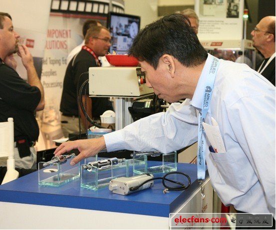 一個(gè)與會(huì)者伸出手去感受一下參展的設(shè)備